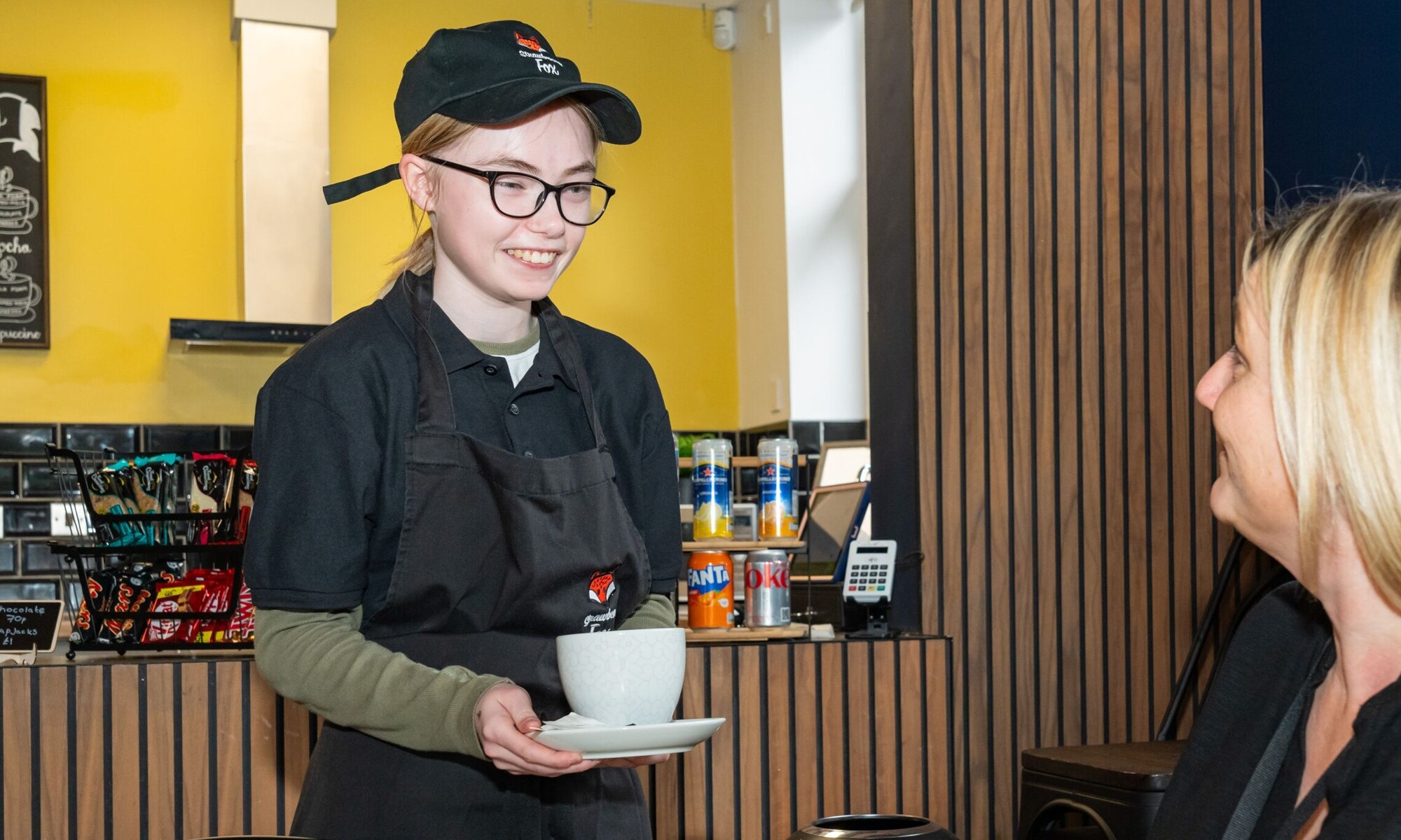 Pioneer house high school - student serving a drink to teacher